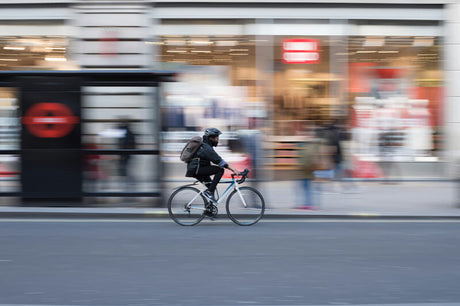 a man wearing helmet rides an electric bike on the road