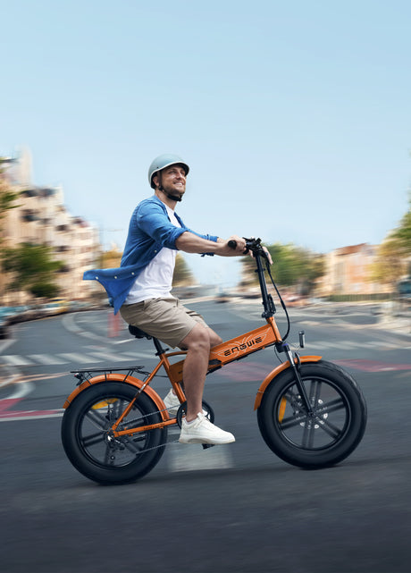 a man riding an orange engwe ep-2 boost collapsible electric bike on the road